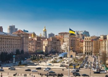 A bustling daytime scene at Independence Square in Kyiv, Ukraine, showcasing historical architecture and city life.
