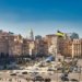 A bustling daytime scene at Independence Square in Kyiv, Ukraine, showcasing historical architecture and city life.