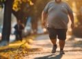 Um homem a caminhar pela rua com uma barriga grande.