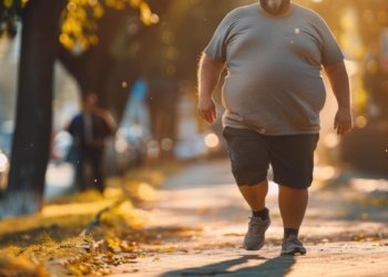 Um homem a caminhar pela rua com uma barriga grande.