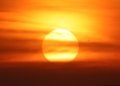 A breathtaking sunset with the sun setting behind clouds and birds flying across the vibrant sky.