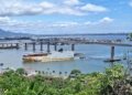 a large boat traveling down a river next to a bridge