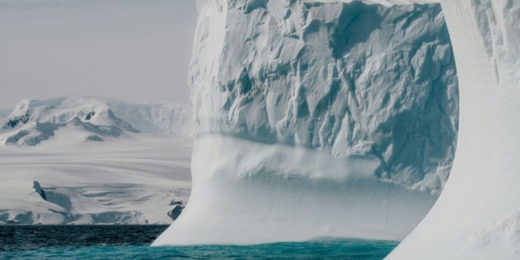 a large iceberg floating in the middle of the ocean
