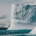 a large iceberg floating in the middle of the ocean