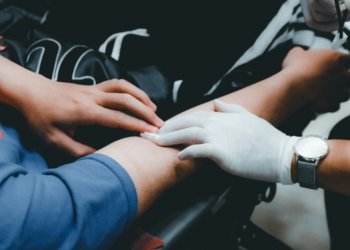 person in blue long sleeve shirt holding persons hand