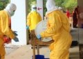 Professionals in yellow PPE suits attending to a procedure outdoors for safety training.