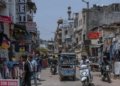 Vibrant street life in Delhi with shops, vehicles, and people capturing the city's energy.