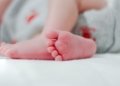 baby wearing white diaper showing foot