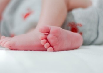 baby wearing white diaper showing foot