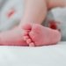 baby wearing white diaper showing foot