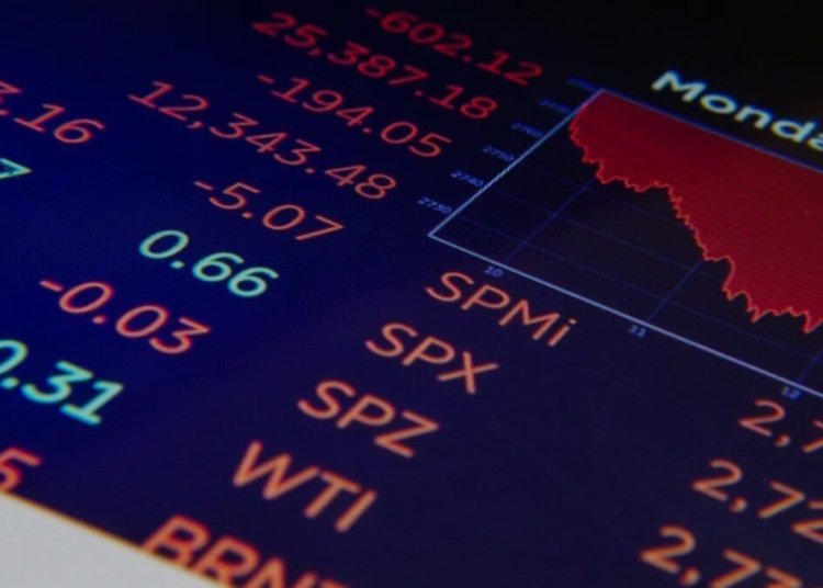 Close-up of a digital stock market graph showing falling trends and financial indices in red and green.