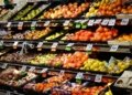 Colorful assortment of fresh fruits neatly arranged on supermarket shelves, ideal for healthy eating themes.