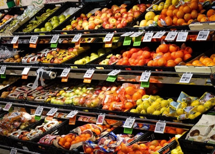 Colorful assortment of fresh fruits neatly arranged on supermarket shelves, ideal for healthy eating themes.