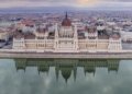 Scenic aerial shot of the Hungarian Parliament Building reflecting on the Danube River in Budapest.