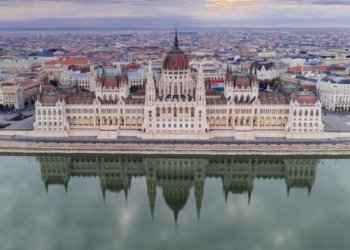 Scenic aerial shot of the Hungarian Parliament Building reflecting on the Danube River in Budapest.