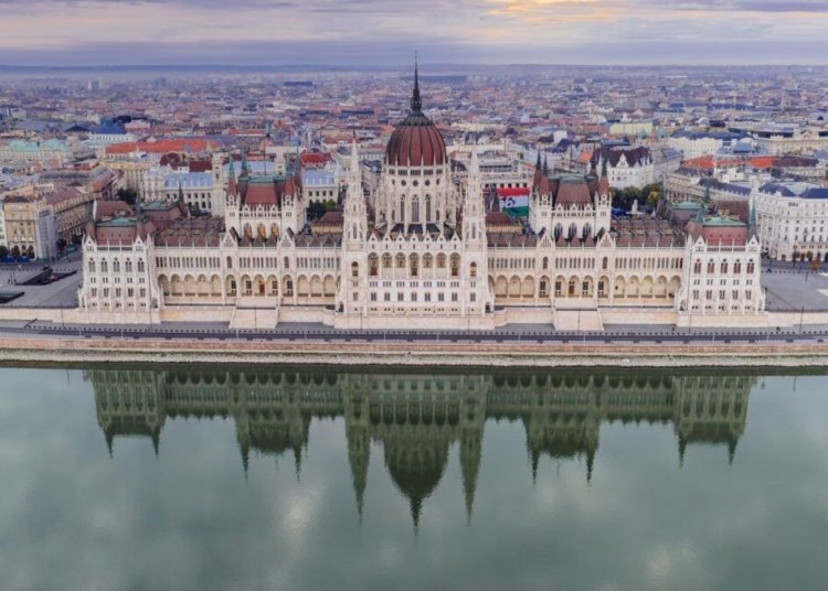 Scenic aerial shot of the Hungarian Parliament Building reflecting on the Danube River in Budapest.