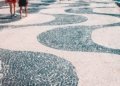 2 women walking on white and blue round concrete floor during daytime
