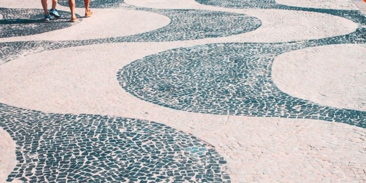 2 women walking on white and blue round concrete floor during daytime