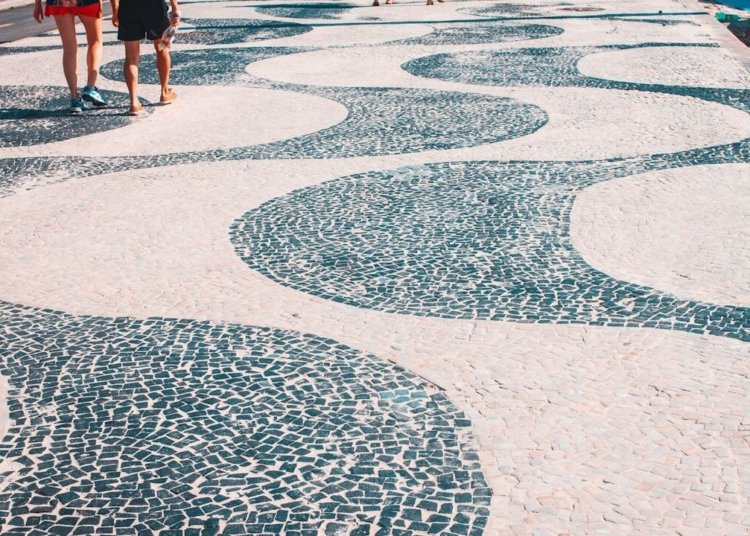 2 women walking on white and blue round concrete floor during daytime