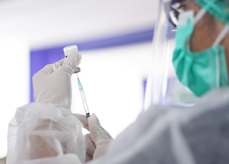 A healthcare worker preparing a syringe with vaccine, showcasing medical precision.