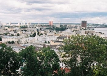 A scenic aerial view of Kyiv cityscape featuring a Ferris wheel and iconic landmarks.