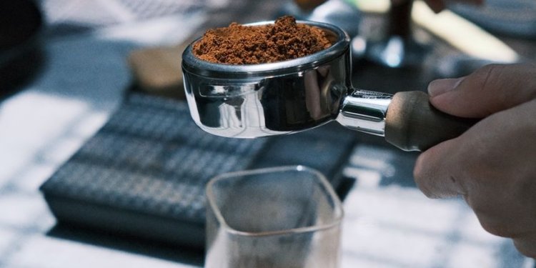 a person is grinding coffee beans in a coffee grinder