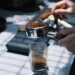 a person is grinding coffee beans in a coffee grinder