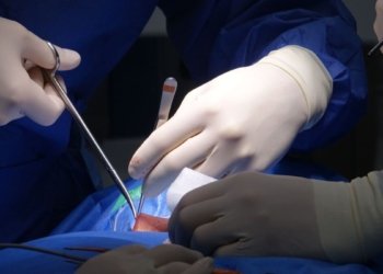 surgeons performing spinal surgery in operating room