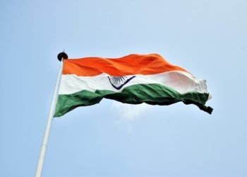 The Indian national flag waves proudly against a clear blue sky in New Delhi.