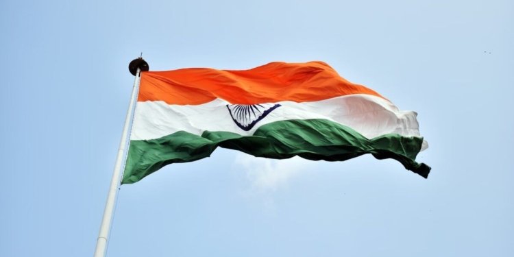 The Indian national flag waves proudly against a clear blue sky in New Delhi.