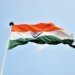 The Indian national flag waves proudly against a clear blue sky in New Delhi.