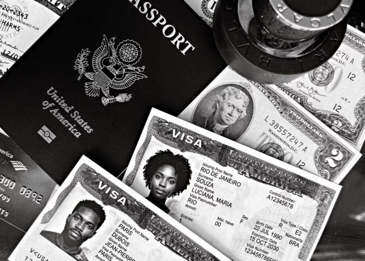 A black and white composition of a US passport, visas, and currency, showcasing travel essentials.