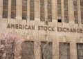 Facade of the American Stock Exchange Building in New York City during spring with blooming trees.