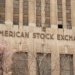 Facade of the American Stock Exchange Building in New York City during spring with blooming trees.